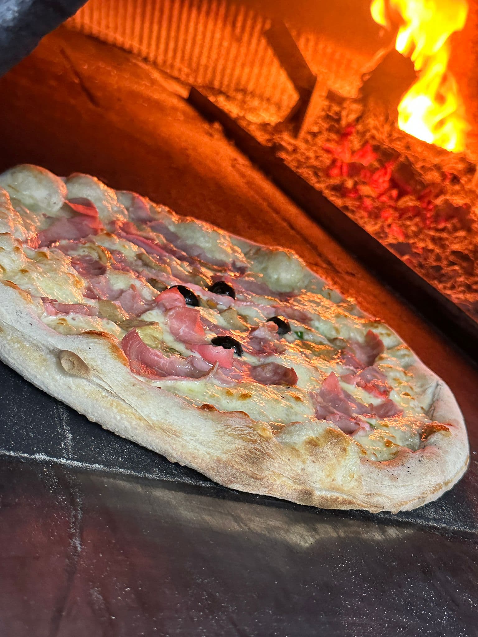Pizza appena sfornata dal forno a legna